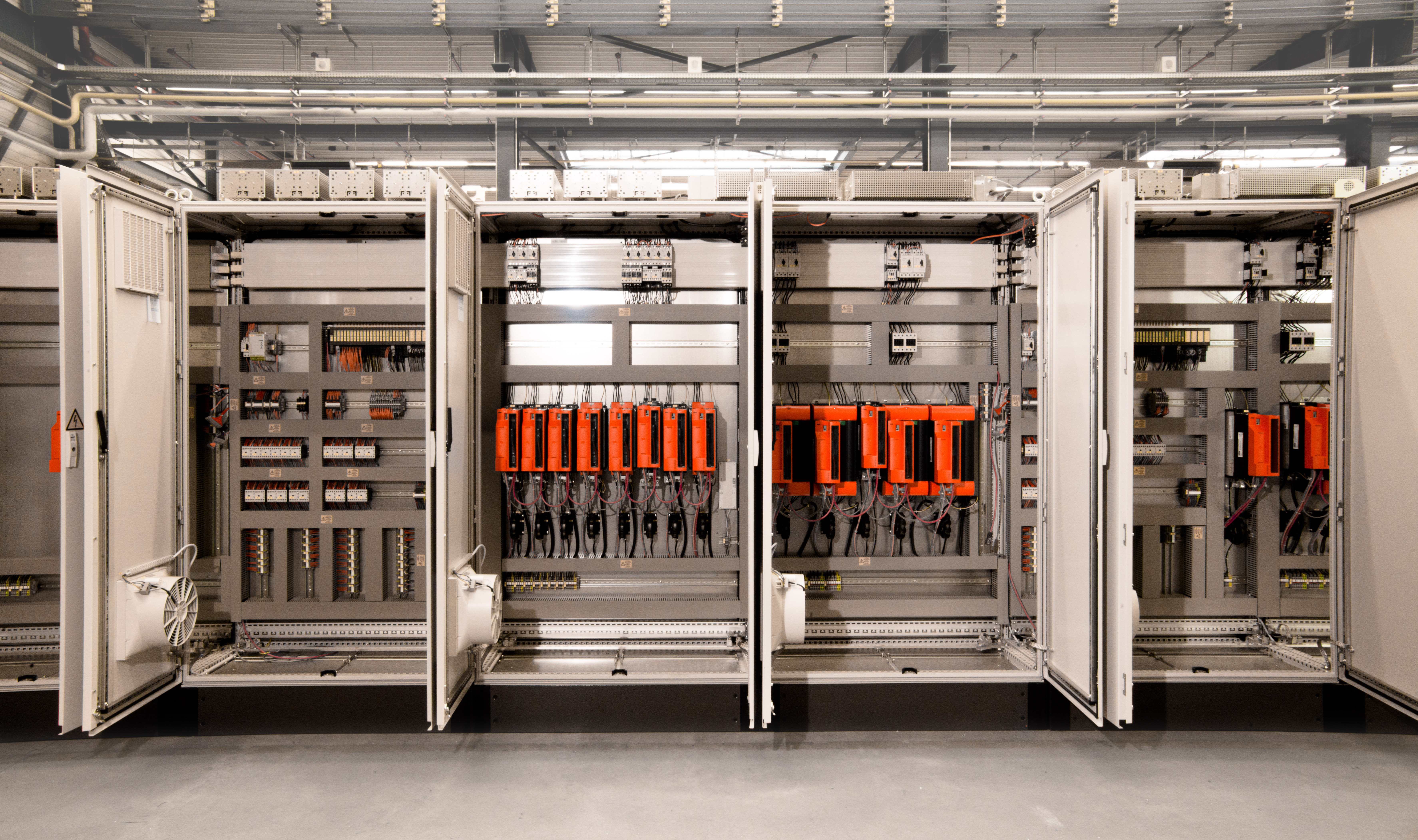 Geöffnete Schaltanlagen und Schaltschränke von SIEMPELKAMP Automation mit Leistungs-, Steuerungs- und Verdrahtungskomponenten.