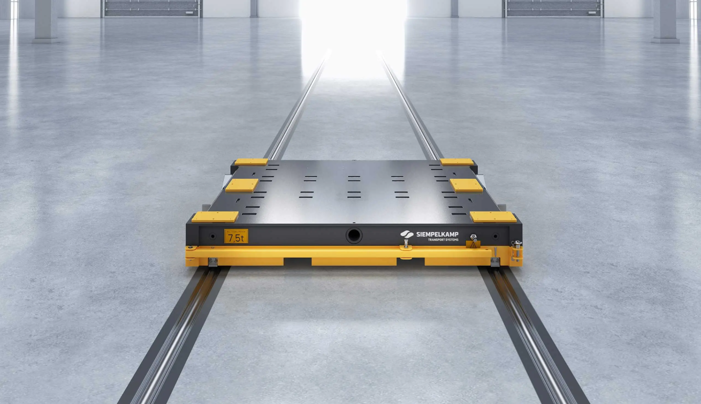 Siempelkamp CustomTrack Transportwagen mit 7,5 Tonnen Tragfähigkeit auf einem bodengeführten Fahrweg in einer Produktionshalle.